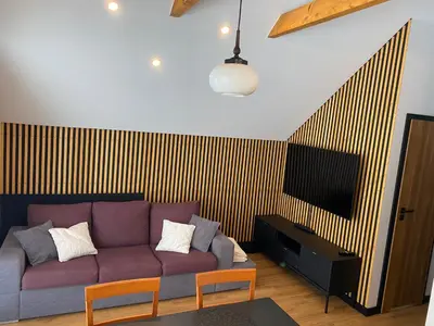 a living room with a purple couch and a tv at Przystanek Zapotocze in Słopnice