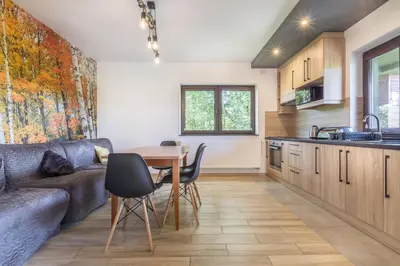 a kitchen and living room with a table and a couch at Przystanek Zapotocze in Słopnice