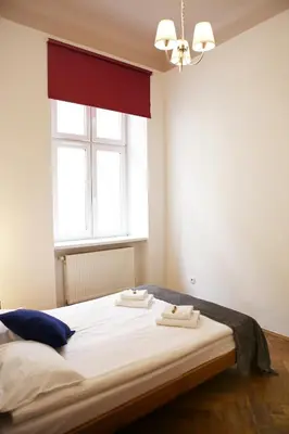 a bedroom with a large bed with two towels on it at Classic apartments Pilsudskiego street in Kraków