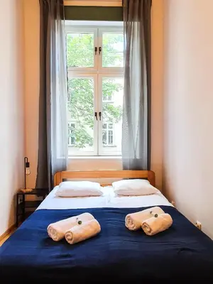 a bed with two towels on it with a window at Classic apartments Pilsudskiego street in Kraków