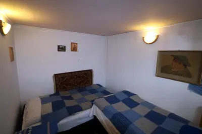 a bedroom with two beds and a painting on the wall at EkoPens in Radziszów