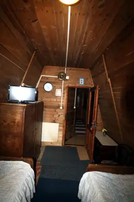 a room with two beds and a clock on the ceiling at EkoPens in Radziszów