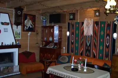 a living room with a table and a fireplace at EkoPens in Radziszów