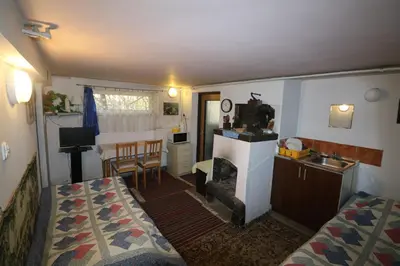 a small room with a bed and a kitchen with a sink at EkoPens in Radziszów