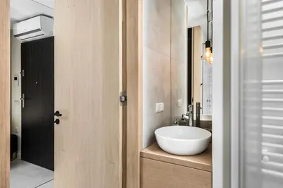 a bathroom with a white bowl sink on a counter at White Room Piłsudskiego 1 in Kraków
