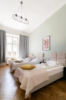 a group of four beds in a room at Apartments Studencka Street, Next to Planty Park in Kraków