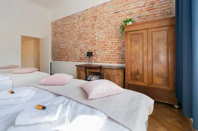a room with two beds and a brick wall at Apartments Studencka Street, Next to Planty Park in Kraków
