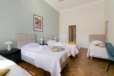 a room with three beds with white sheets at Apartments Studencka Street, Next to Planty Park in Kraków