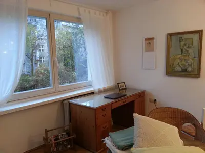 a room with a desk and two windows at Pokój z widokiem in Kraków