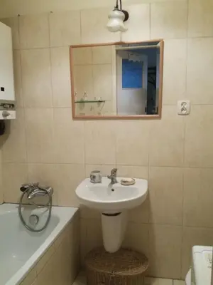 a bathroom with a sink and a mirror and a tub at Pokój z widokiem in Kraków