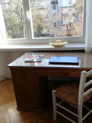 a desk with a laptop on it in front of a window at Pokój z widokiem in Kraków