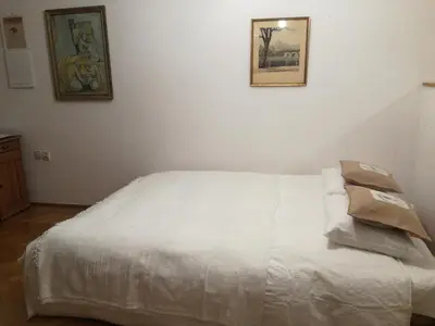 a white bed in a room with two pictures on the wall at Pokój z widokiem in Kraków