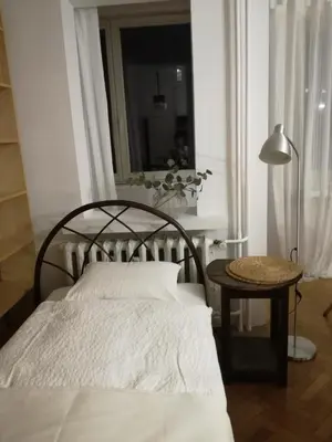 a bedroom with a bed and a table and a window at Pokój z widokiem in Kraków