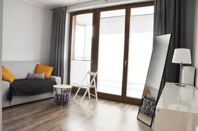 a living room with a couch and a bed and glass doors at Dworska 1A - studio by Homeprime in Kraków