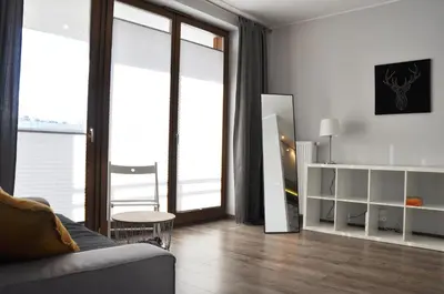 a living room with a couch and large windows at Dworska 1A - studio by Homeprime in Kraków