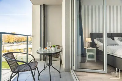 a balcony with a table and chairs and a bed at Exclusive Vermelo Apartment in Kraków