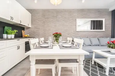 a kitchen and living room with a white table and chairs at Exclusive Vermelo Apartment in Kraków