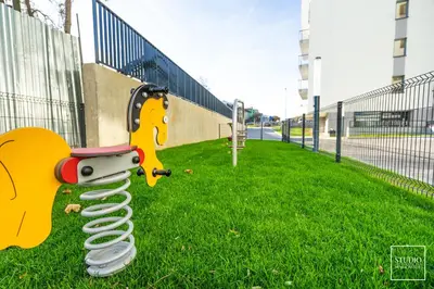 a toy dog on the grass next to a fence at Exclusive Vermelo Apartment in Kraków