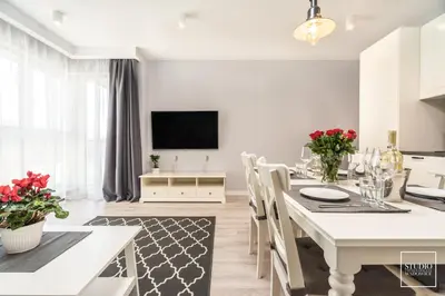 a kitchen and dining room with a white table and chairs at Exclusive Vermelo Apartment in Kraków
