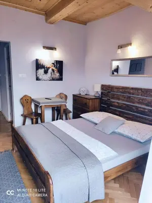 a bedroom with a large bed and a table at Podkowa in Myślenice