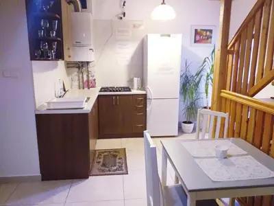 a kitchen with a sink and a refrigerator and a table at Podkowa in Myślenice