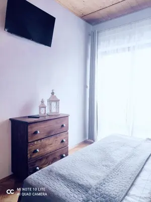 a bedroom with a bed and a dresser and a window at Podkowa in Myślenice