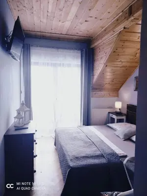 a bedroom with a bed and a large window at Podkowa in Myślenice