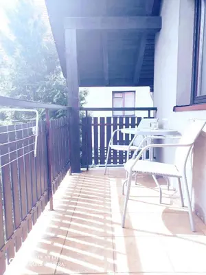 a patio with tables and chairs on a balcony at Podkowa in Myślenice