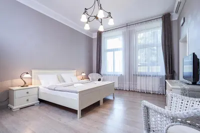 a bedroom with a bed and a tv and a couch at Elegant Apartments in Kraków