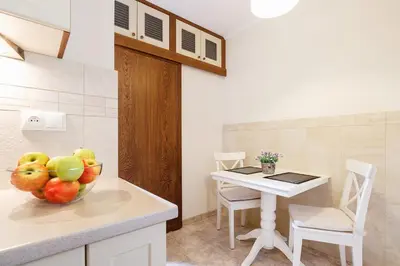 a kitchen with a table and a bowl of fruit at Elegant Apartments in Kraków
