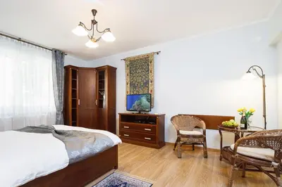 a bedroom with a bed and a table and a chair at Elegant Apartments in Kraków