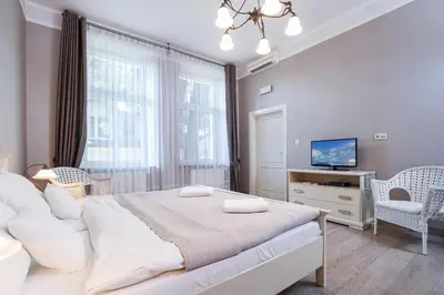 a bedroom with a large bed and a tv at Elegant Apartments in Kraków