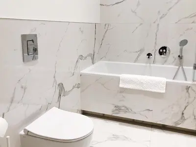 a white bathroom with a toilet and a bath tub at TCF Home - Apartment with Free Garage in Kraków