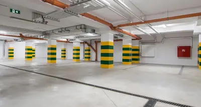 an empty parking lot with yellow and green columns at TCF Home - Apartment with Free Garage in Kraków