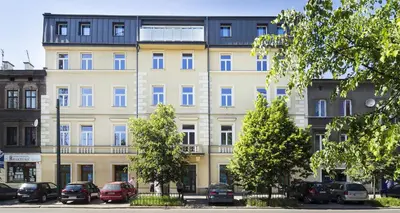 a large building with cars parked in front of it at TCF Home - Apartment with Free Garage in Kraków