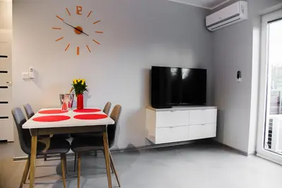 a dining room with a table and a clock on the wall at ULMA apartment in Wieliczka