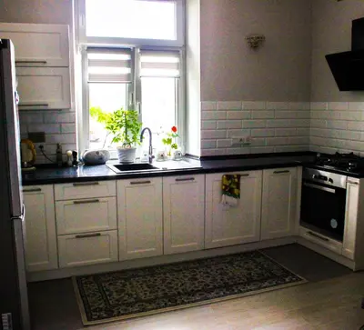 a kitchen with white cabinets and a sink and a window at Apartment Cracow in Kraków