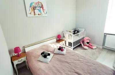 a bedroom with a pink bed with stuffed animals on it at Apartment Cracow in Kraków