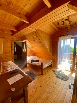 a large wooden room with a bed and a window at Górska Przystań in Wola Piskulina
