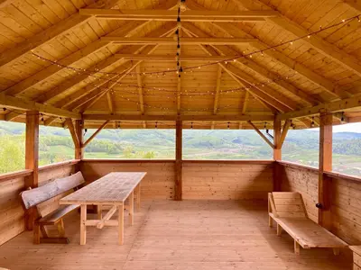 a wooden porch with a wooden table and benches at Górska Przystań in Wola Piskulina