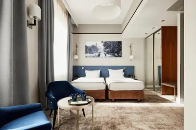 a hotel room with two beds and a table at Hotel Unicus Krakow Old Town - Destigo Hotels in Kraków