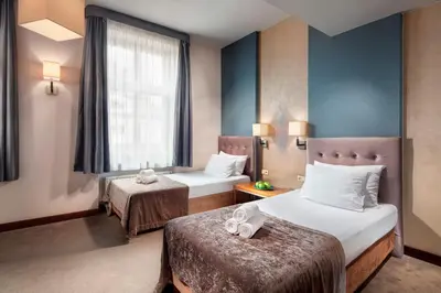 a hotel room with two beds and a window at Hotel Unicus Krakow Old Town - Destigo Hotels in Kraków