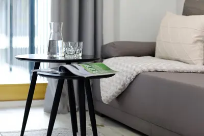 a living room with two tables next to a couch at Native Apartments Lubelska 10 in Kraków