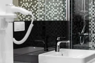 a bathroom with a sink and a shower with a faucet at Native Apartments Lubelska 10 in Kraków