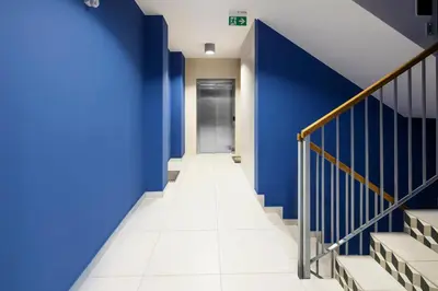a hallway with blue walls and stairs at Native Apartments Lubelska 10 in Kraków