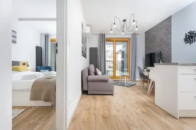 a bedroom with a bed and a living room at City of the Kings-Silver Apartment No 2- Lubelska 10 in Kraków