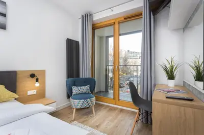 a bedroom with a bed and a desk and a chair at City of the Kings-Silver Apartment No 2- Lubelska 10 in Kraków