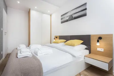 a bedroom with a bed with white sheets and yellow pillows at City of the Kings-Silver Apartment No 2- Lubelska 10 in Kraków
