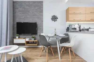 a living room with a table and chairs and a tv at City of the Kings-Silver Apartment No 2- Lubelska 10 in Kraków
