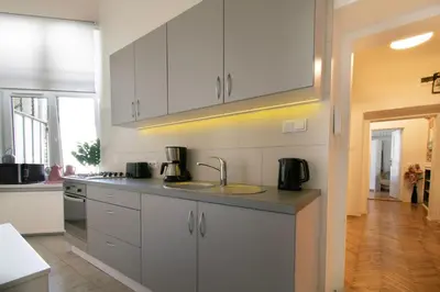 a kitchen with white cabinets and a sink at Vintage Apartment Gertrudy street in Kraków